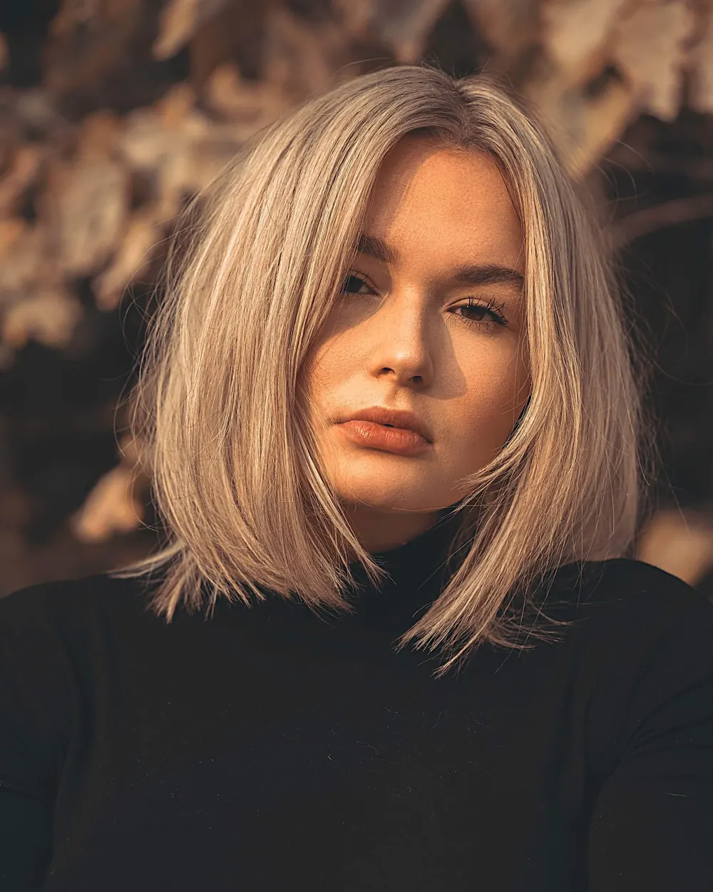 Portrait of a woman with blonde hair in warm autumn light, showcasing natural beauty.